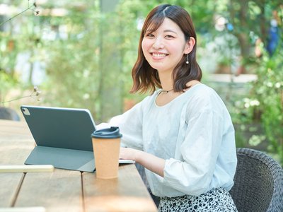 カフェでタブレット端末を操作している大学生